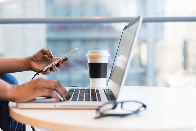 A photo of a laptop, coffee, and glasses on a desk